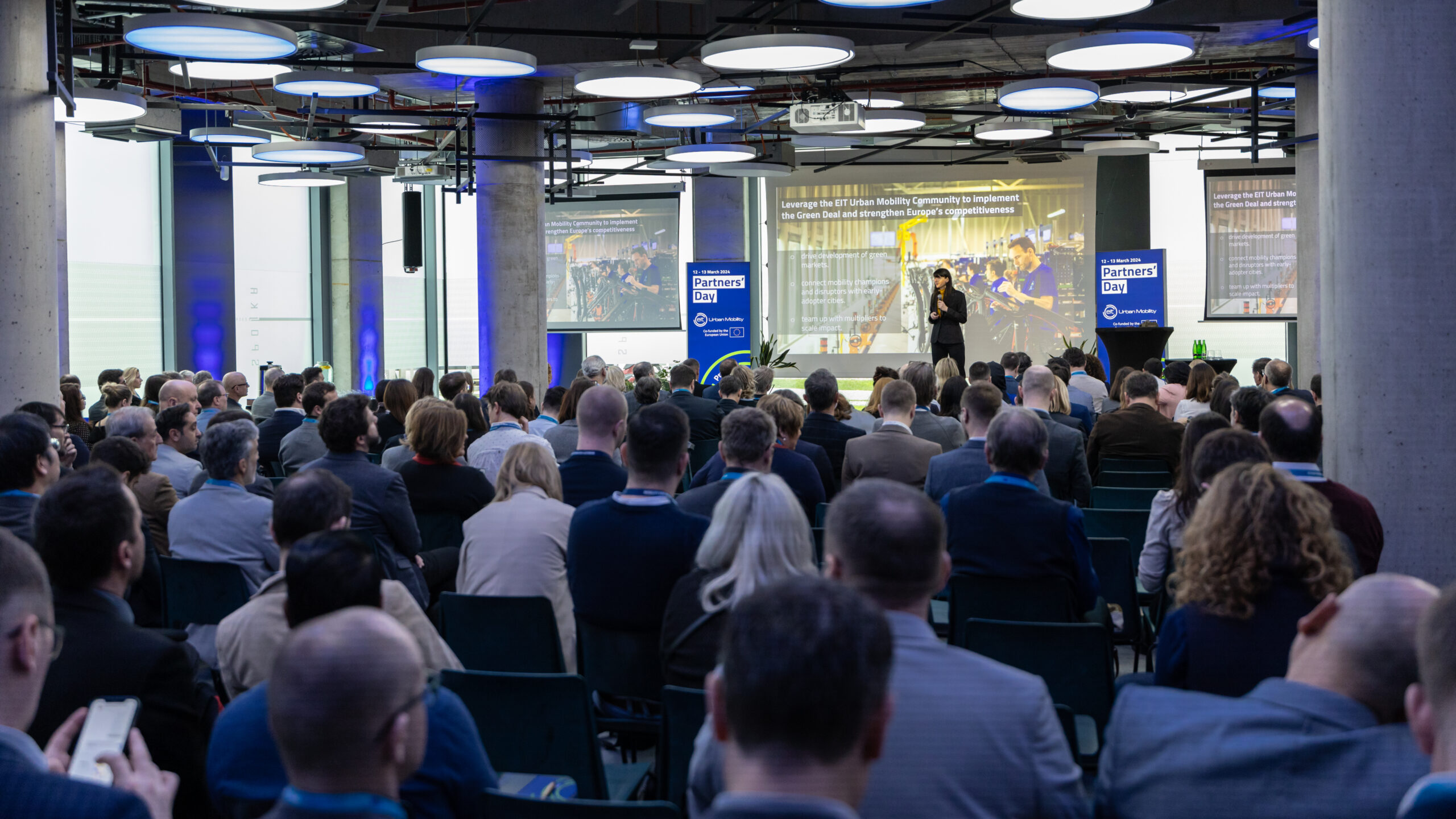 room full of people sitting listening to a presentation